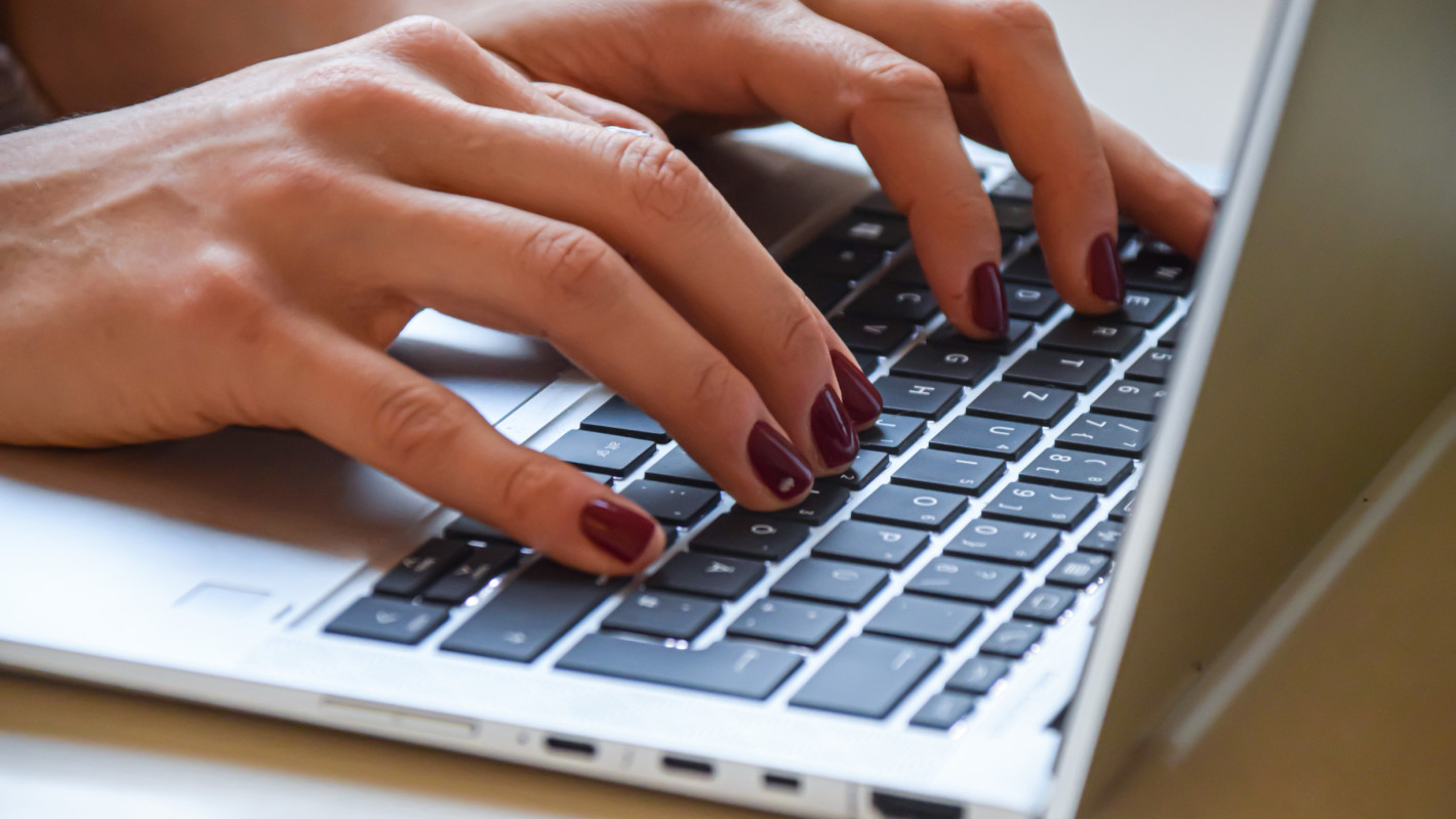 Nahaufnahme von einer Frau die am Laptop arbeitet